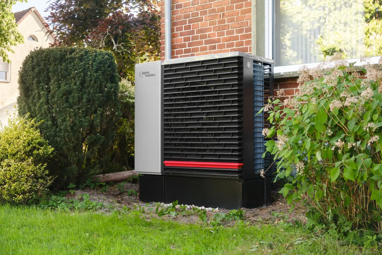 Air source heat pump unit installed outside a brick house