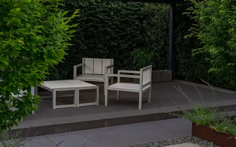 Newly laid stone patio flags with garden furniture in summer