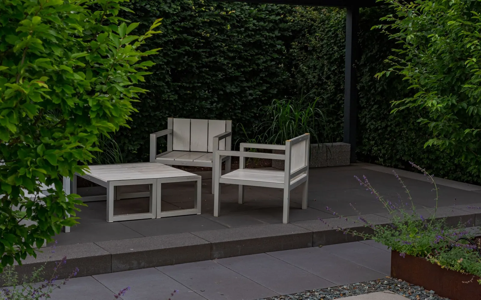 Newly laid stone patio flags with garden furniture in summer