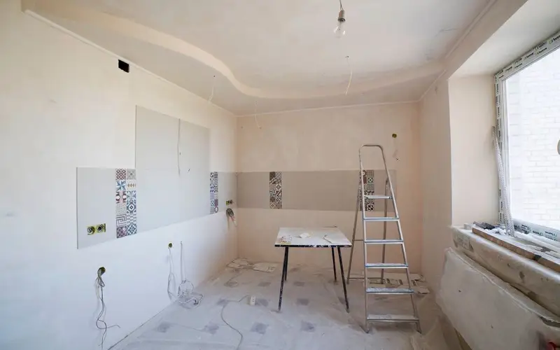 Plasterer smoothing fresh skim on a wall with a steel trowel