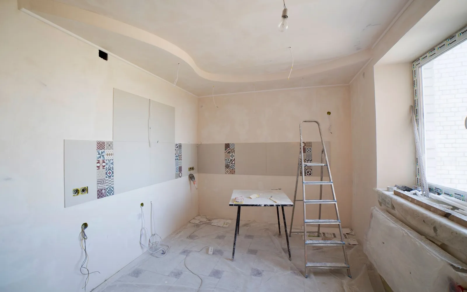 Plasterer smoothing fresh skim on a wall with a steel trowel